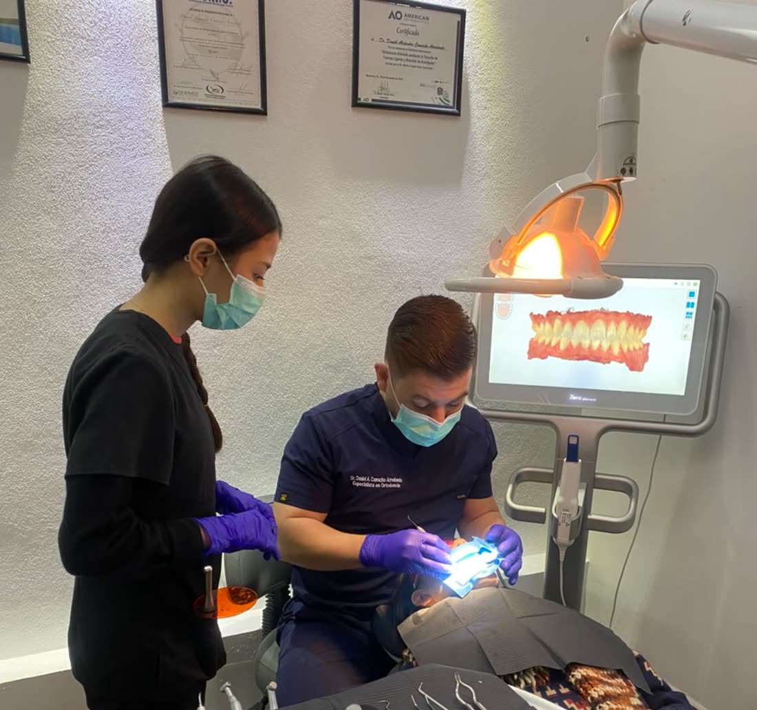 El Dr. Daniel Camacho trabajando con su asistente, junto al escáner iTero Element