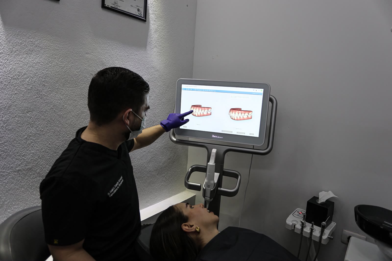 El doctor muestra a una paciente la simulación de su tratamiento en la pantalla del escáner iTero